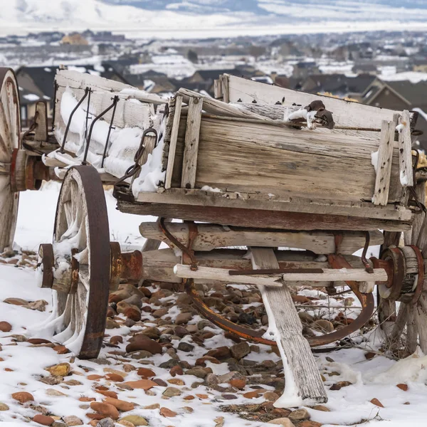 Vierkante verweerde houten wagon met kettingen en roestig wiel bekeken in de winter — Stockfoto