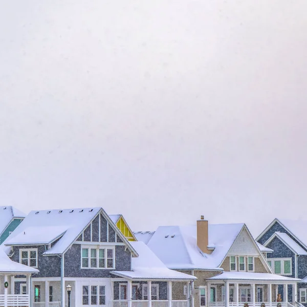 Clear Square Casas agradáveis com telhados cobertos de neve contra um céu nublado no inverno — Fotografia de Stock