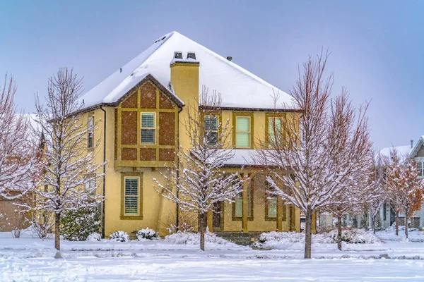 Winter home with frosty trees on the snow covered front yard in Daybreak Utah