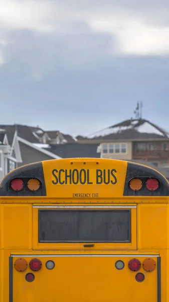 Pionowy żółty autobus szkolny z prostokątnym oknem i kilkoma światłami sygnałowymi z tyłu — Zdjęcie stockowe