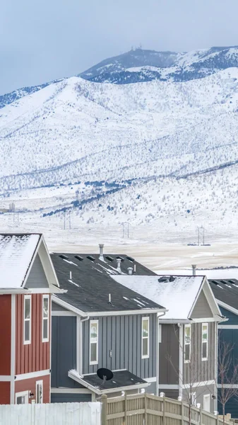 Vertical Casas coloridas contra uma paisagem de tirar o fôlego revestido de neve no inverno — Fotografia de Stock