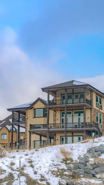 Vertical atractiva casa de montaña con un fondo de cielo azul nublado en invierno — Foto de Stock