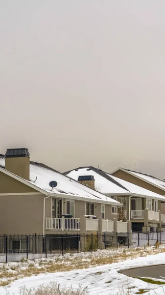 Klare vertikale Hausfassade gegen schneebedeckten Berg und weißen Himmel im Winter — Stockfoto