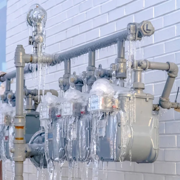 Clear Square Water meters and pipes outside a building in Eagle Mountain with brick wall