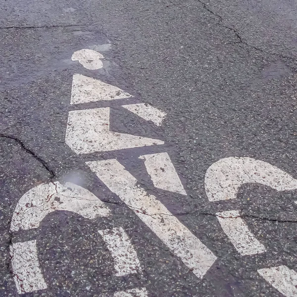 Clear Square Bicycle lane sign painted on a road with cracks