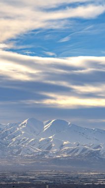 Dikey çerçeve Çarpıcı güneşli dağ altında kar kaplı