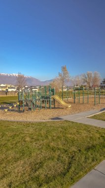 Bir çim ortasında bir oyun alanı Dikey Güneşli gün görünümü