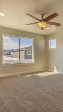 Dikey çerçeve Bej duvar boyası ve halı zeminli yeni bir evin boş odası