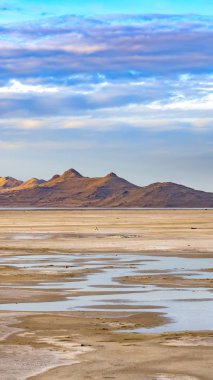 T ile parlak mavi gökyüzü altında bir gölün Dikey Engin kumlu kıyı