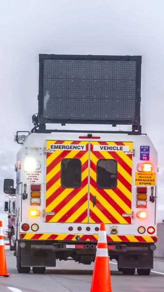 Vertical Back view of an emergency vehicle on the road with traf — Stock Photo, Image