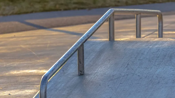 Panorama verliest een schuine betonnen helling in een park verlicht door s — Stockfoto