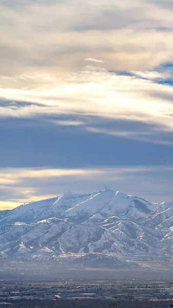 鮮やかな下に雪で覆われた垂直印象的な日当たりの良い山 ストックフォト