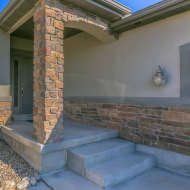 Kayalık bir avluve küçük ön veranda ile bir ev Kare çerçeve Cephe