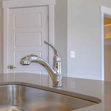 Kare çerçeve Parlak paslanmaz çelik lavabo ve musluk bir mutfak içinde tezgahüzerinde