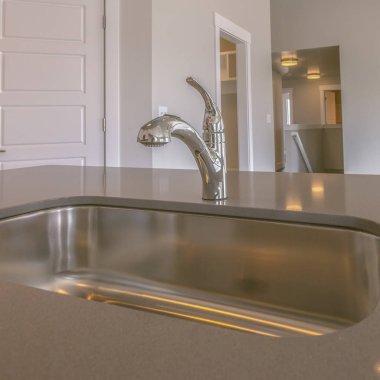 Kare çerçeve Yeni bir evin mutfak içinde paslanmaz çelik lavabo ve musluk Gleaming