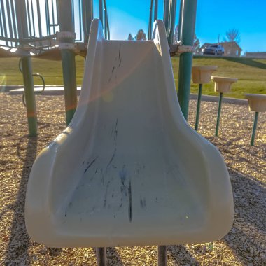 Arka planda parlak bir şekilde parlayan güneşi olan bir oyun alanında Kare Slayt