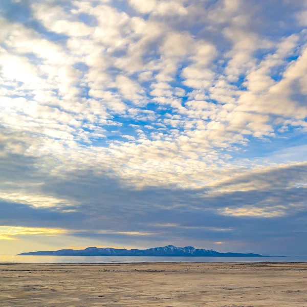 Vierkante grenzeloze blauwe hemel met grijze en witte wolken over een uitgestrekt — Stockfoto