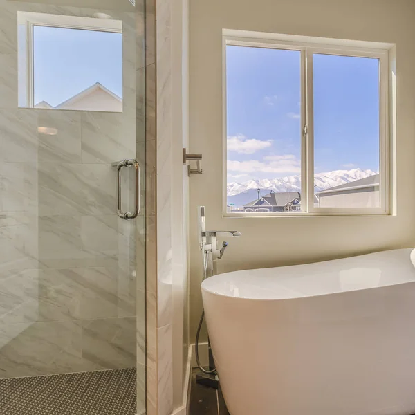Kwadratowa błyszcząca wanna i oddzielny prysznic wewnątrz nasłoneczliwej łazienki nowego domu — Zdjęcie stockowe