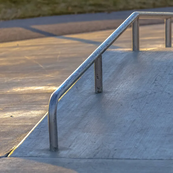 Quadrado perder de uma rampa de concreto inclinado em um parque iluminado pela luz solar em um dia ensolarado — Fotografia de Stock
