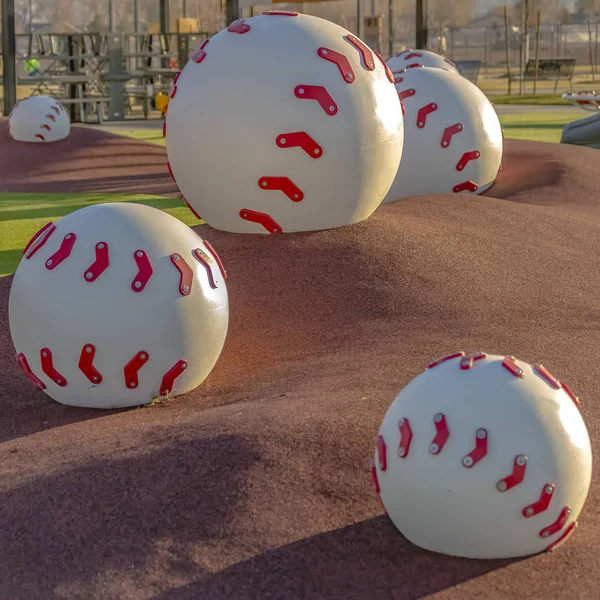 Огромное бейсбольное украшение на вершине коричневых курганов на детской площадке — стоковое фото