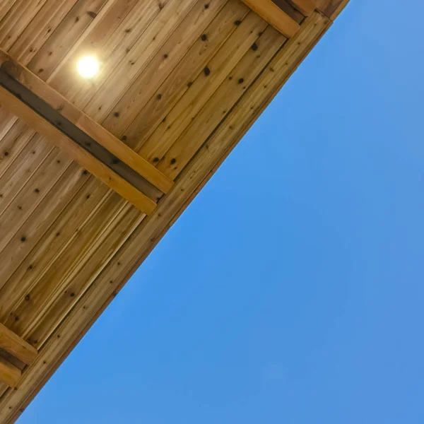 Square frame Close up view of the underside of a flat roof with blue sky in the background — Stock Photo, Image