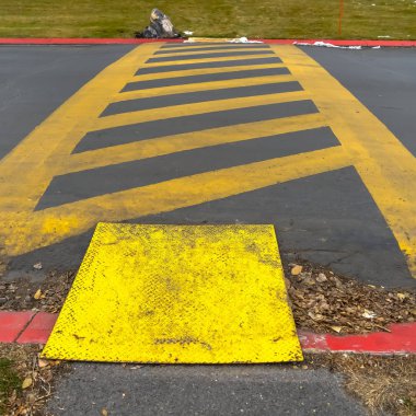 Kare kare Asfalt bir yolda boyanmış paralel çizgiler arasında sarı çapraz çizgiler