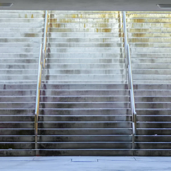 Rama kwadratowa szeroki lot schodów z błyszczącymi metalowymi poręczami pod budynkiem — Zdjęcie stockowe