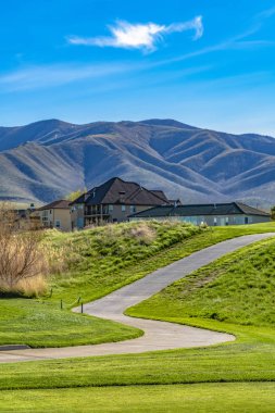 Parlak yeşil otlar ve güzel evler ile bir tepeüzerinde Yol