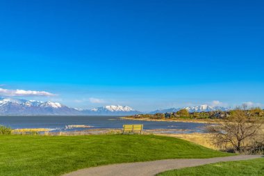 Göl ve mountai bakan yol ve bank ile çimenli alan