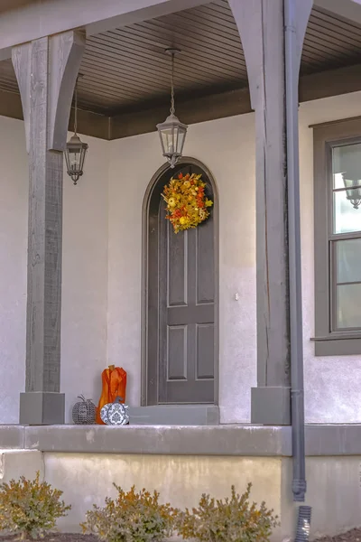 Fachada de una casa con un pequeño porche delantero y puerta arqueada w — Foto de Stock