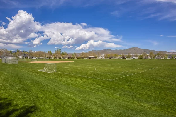 Terrain de football et terrain de baseball avec vue sur la montagne et nuageux — Photo