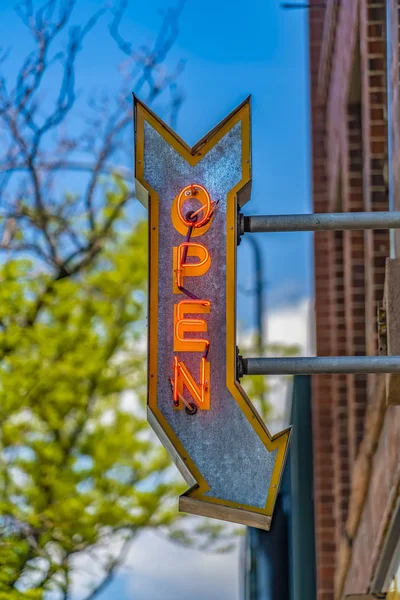 Rotes Backsteingebäude mit offenem Pfeilschild an einem sonnigen Tag — Stockfoto