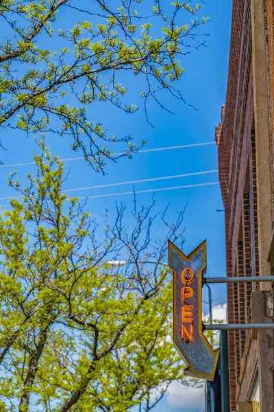 Flèche ouverte sur un bâtiment avec des arbres vibrants et un ciel bleu en arrière-plan — Photo