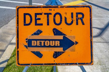 Ok ile yıpranmış turuncu ve mavi Detour işareti yakın