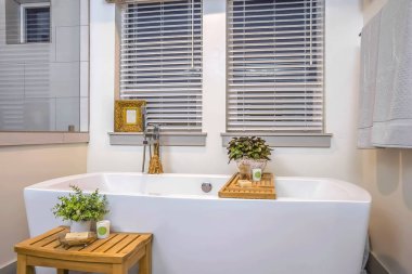 Lekesiz beyaz küvet ayna ve iki pencere ile rahatlatıcı banyo iç