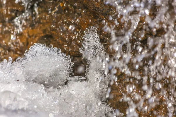 Close up de gelo cristalino e rocha marrom coberto com água gelada brilhante — Fotografia de Stock