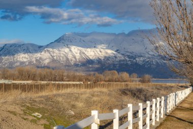Beyaz bir çitin diğer tarafında ki göl eteklerinin yakınındaki şantiye