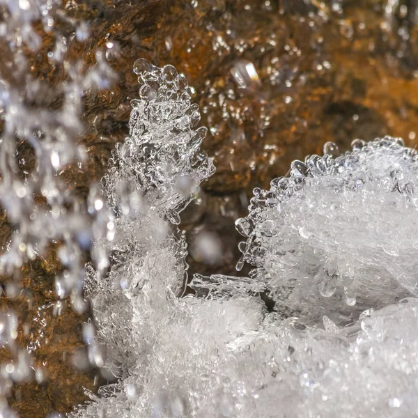 Cuadrado Primer plano de hielo cristalino y roca marrón cubierta de agua helada brillante —  Fotos de Stock