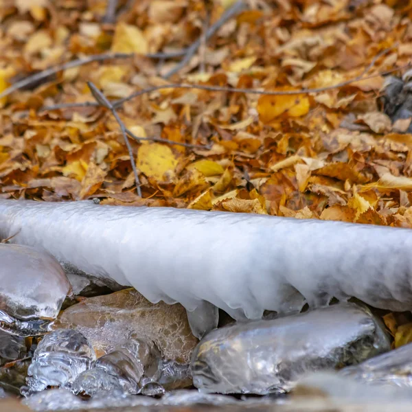 Rahmenquadrat Nahaufnahme eines Baches mit gezackten Felsen und durchscheinendem gefrorenem Wasser im Winter — Stockfoto
