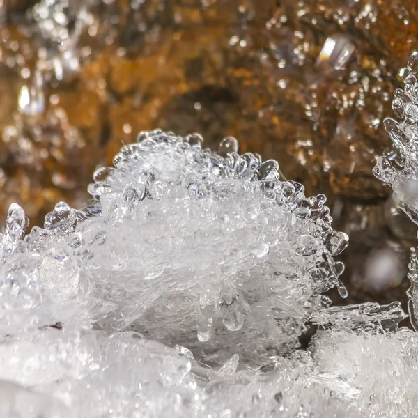 Frame Square Primer plano de hielo cristalino y roca marrón cubierta con agua helada brillante — Foto de Stock