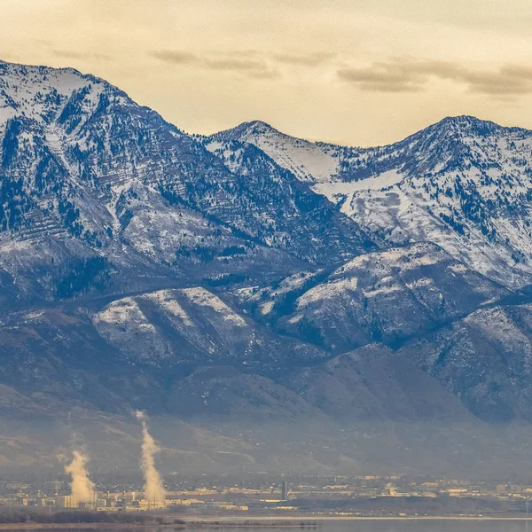 Каркасная площадь Панорама поразительной горы против облачного неба, возвышающегося над туманной долиной — стоковое фото