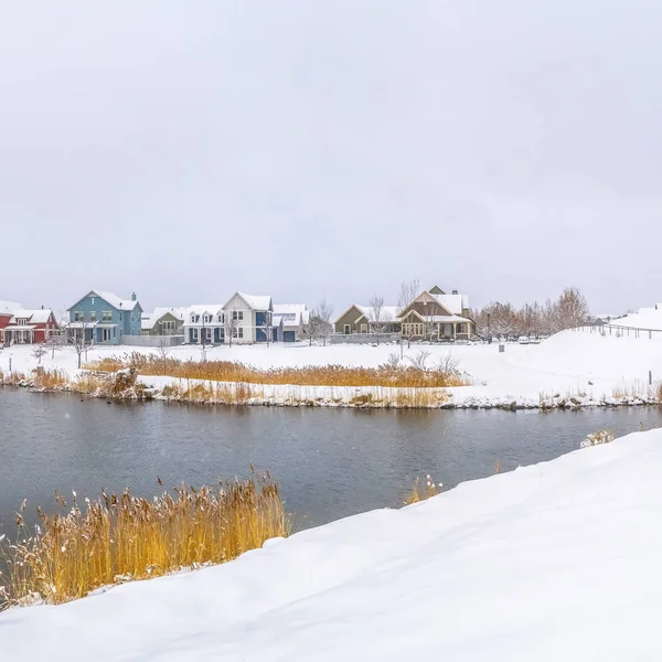 Marco Cuadrado Panorama de un lago plateado con casas distantes contra el cielo nublado en invierno — Foto de Stock