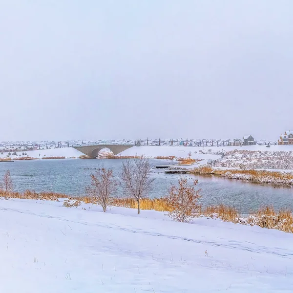Escenario de invierno idílico con un tranquilo lago plateado en medio de un paisaje cubierto de nieve — Foto de Stock