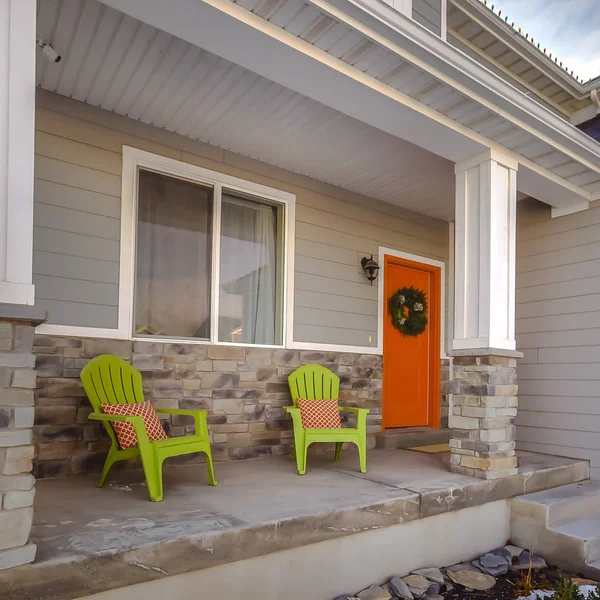 Fachada cuadrada del hogar con puerta delantera naranja brillante decorada con una corona festiva — Foto de Stock