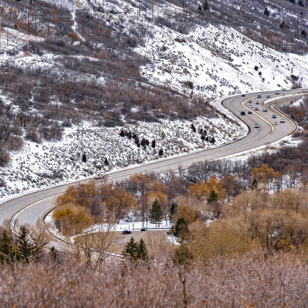 Négyszögletes panoráma olyan útról, amely egy roppant havas hegyen keresztül szeli át a telet — Stock Fotó