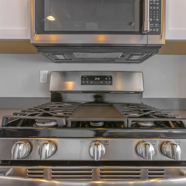 Square Close up di forno a microonde a parete e piano cottura di una gamma all'interno della cucina — Foto Stock