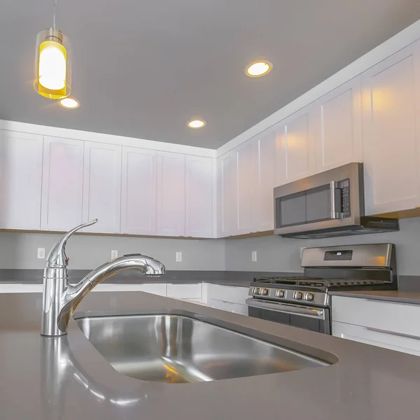 Quadratisch glänzende Arbeitsplatte mit Wasserhahn und Spüle in der modernen Küche eines Hauses — Stockfoto