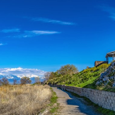 Güneşli bir günde izlenen bir gölü çevreleyen patikaların ve kahverengi otların Çerçeve Çerçeve Kare Panoraması