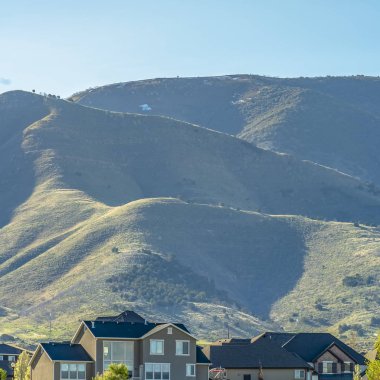 Kare Kare Evler güneşli bir günde parlak gökyüzü altında bir dağın dibinde