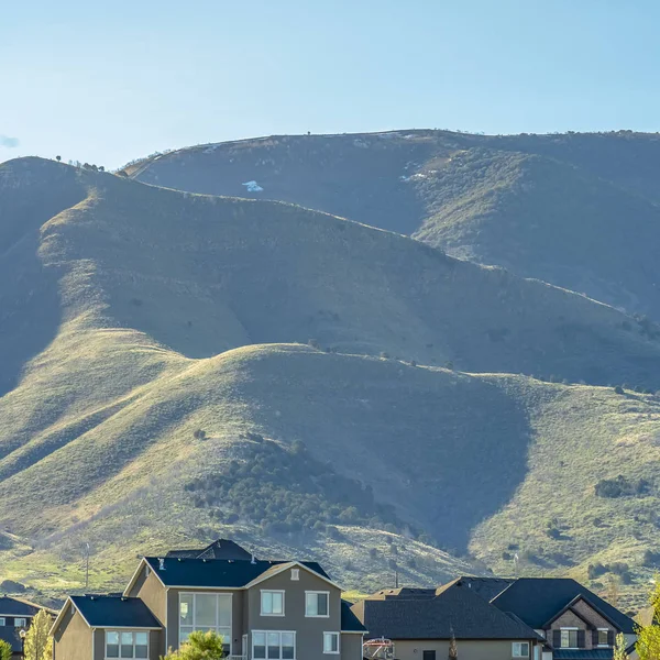 Frame Square Casas na base de uma montanha sob o céu brilhante em um dia ensolarado — Fotografia de Stock